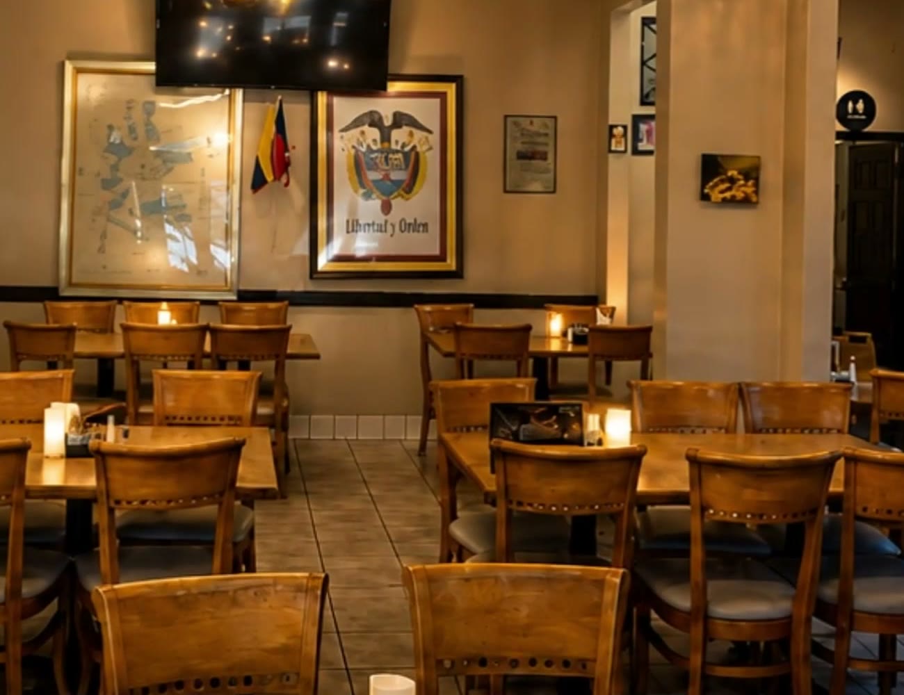 Framed Colombian artwork and the coat of arms above the dining tables