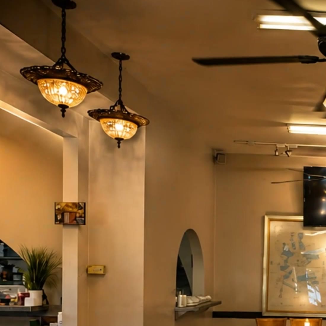 Amber glass chandeliers glowing beside an arched doorway